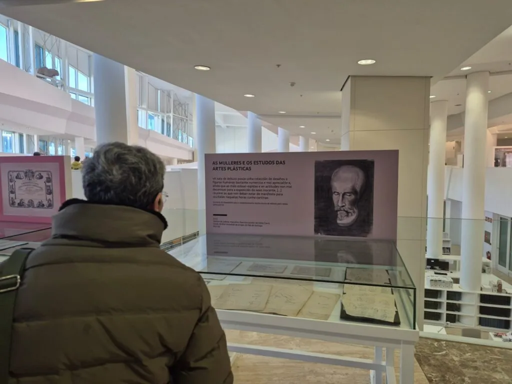 Un visitante observa un panel da exposición sobre as mulleres e os estudos das artes plásticas