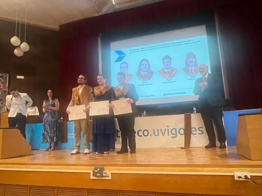 Tres graduados amosan o seu diploma no acto de graduación da Escola de Telecomunicación de Vigo